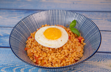 RECIPE FOR BLE WITH BACON, TOMATO AND SHALLOTS, SERVED WITH FRIED EGG. High quality photo