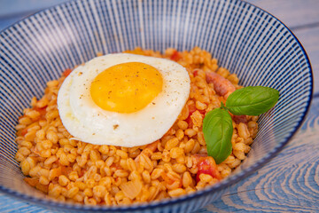 RECIPE FOR BLE WITH BACON, TOMATO AND SHALLOTS, SERVED WITH FRIED EGG. High quality photo