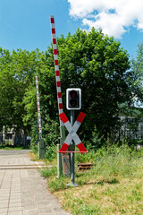 Fototapeta na wymiar Level crossing with barriers, traffic lights and St. Andrew's cross