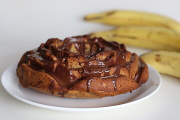 Rose shaped whole wheat plantain cake topped with chocolate sauce.