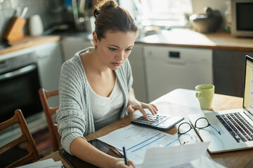 Young woman going over her bills at home in the morning