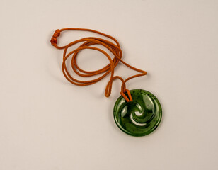 Green jade jewelry with an orange cord. This New Zealand stone is called 