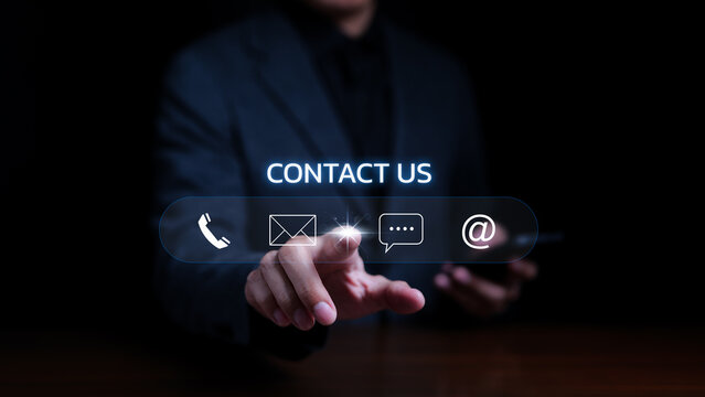 Contact Us Or The Customer Support Hotline People Connect. Businessman Using Mobile Phone And Using Hand Touching Virtual Icons Call Phone, Email, Address, And Live Chat. Customer Service Call Center.