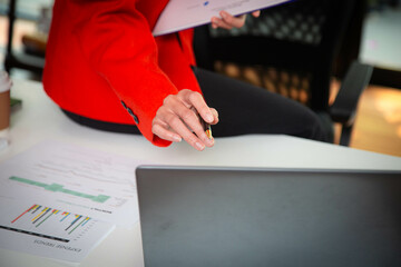 Businesswoman searching through laptop for online real estate on office desk
