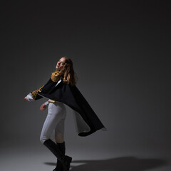 A glamorous blonde in a carnival uniform with epaulettes, posing with pretentious poses, a show host or a pop artist