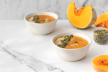Bowls of pumpkin soup with mashed potatoes and seeds. Autumn menu. Copy space