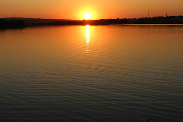 Fototapeta premium A sunset over a body of water