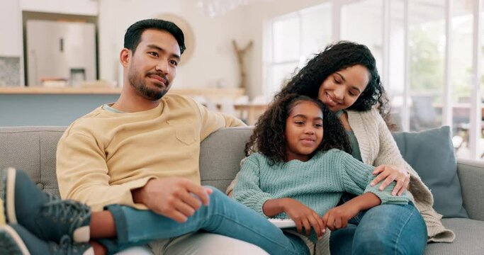 Happy family, parents and child watching tv with a remote in a living room with care and love. Multiracial man, woman and girl kid on home sofa for fun, quality time and bonding or streaming movies