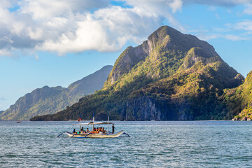 Tropical island landscape with bangca traditional philippines boat full of tourist, El Nido, Palawan, Philippines