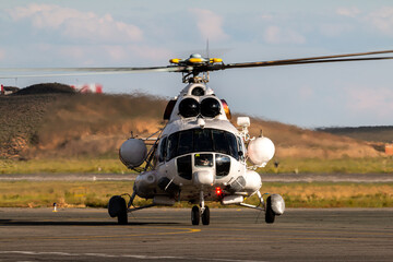 Front view of the white transport helicopter on the airport apron