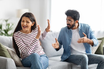 Furious eastern man shouting at his emotional wife, home interior