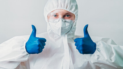 Healthcare specialist. Coronavirus precautions. Like gesture. Happy female doctor woman in ppe goggles with thumbs up hands sign isolated on grey background.