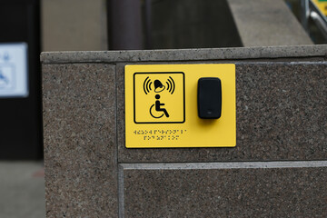 Yellow plate with image of disabled person in wheelchair and call button. Disabled person sign and...