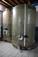 Two large plastic storage tanks used in the production of wine making. The tanks are half filled...