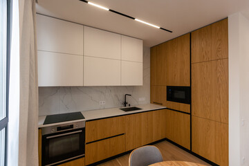 Interior of luxurious modern kitchen equipment, grey and oak cabinets