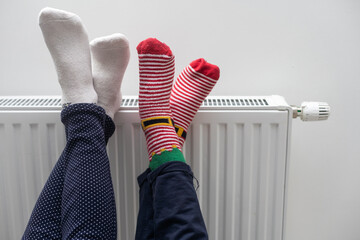 legs of mother and daughter near the radiator