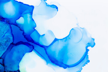 Macro close-up of blue alcohol ink layers and splashes, abstract background. Fluid ink, colorful full frame textured background. Vibrant color. Art for design.