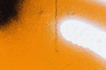 Macro close-up of a wall spray painted with orange, black and white with splashes. Abstract full frame textured splattered graffiti background with copy space. © tuomaslehtinen
