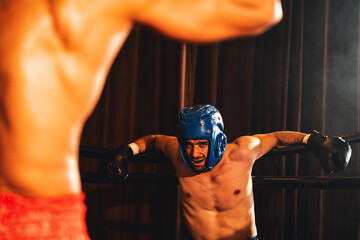 Boxer fighter with boxing helmet in fierce and intense fight while the competitor struggling to...