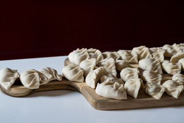 raw gyoza, before cooking, on a wooden board. close-up view in the kitchen
