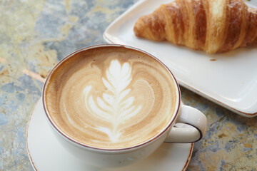 a cup of late coffee with flower shape design on top at cafe 