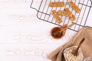 Top view of cereal muesli bar with nuts and honey on a white wooden table. Healthy sweet dessert...