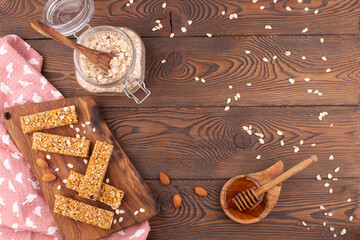 Top view of cereal muesli bar with nuts and honey on a wooden table. Healthy sweet dessert snack