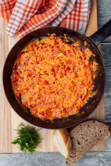 omelette with tomatoes in a frying pan.