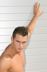attractive and muscular young man dressed in a very short swimsuit,
