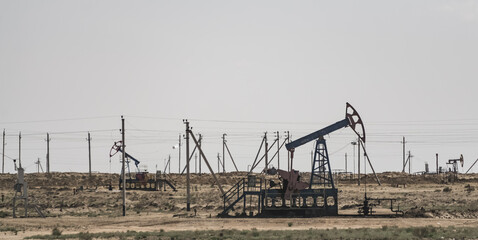 Fototapeta na wymiar Land drilling rigs for oil production in the Kazakh steppes, industrial structures for oil production