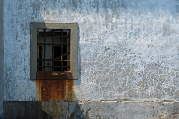 Rust coloring a wall underneath a gated window