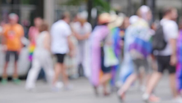 blurred march LGBT community, lesbian, gay, bisexual, transgender with rainbow flags, Gay pride parade in city with rainbow flags, against discrimination on queer people, 4K video with sound