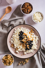 Homemade cottage cheese with fresh blackcurrants and walnuts on a plate top and vertical view