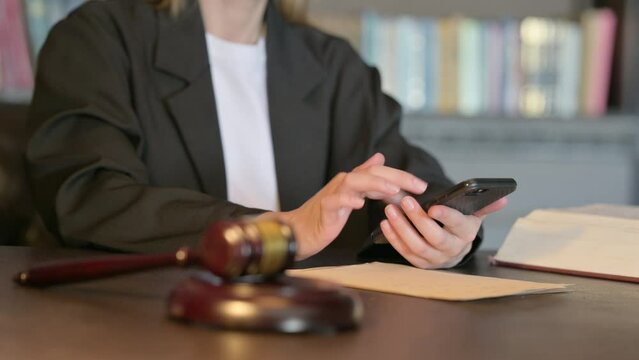 Close Up of Young Judge using Smartphone in Court
