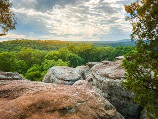 Fototapeta na wymiar Breathtaking views standing at the top of the natural sandstone rock formations at Garden of the Gods, located within Shawnee National Forest. Standing at the top, looking out over a lush green forest