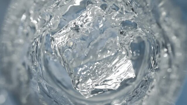 Super Slow Motion Detail Shot of Ice Cube Falling into Glass with Vodka at 1000 fps.