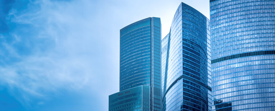 Modern city. Glass skyscrapers. Skyscrapers against blue sky. Modern city in sunny weather. Downtown on summer day. Modern architecture. City skyscrapers. Business quarter. Corporate real estate