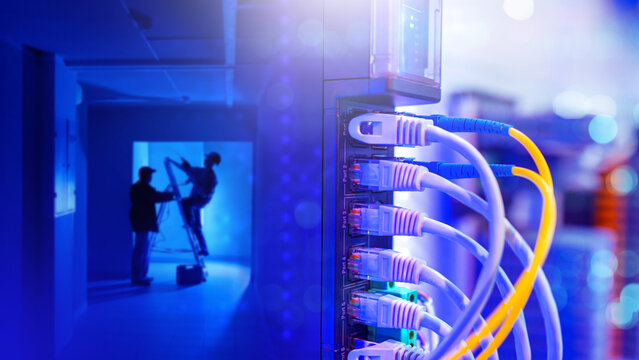 Network equipment close-up. Builders with ladder in dark. Installers install network equipment. Internet tech. Fiber optic internet wires. Fragment network router. Installation electrical equipment