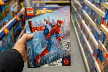 Fototapeta premium Lego Spiderman in hands of buyer. Spiderman toy in a toy store. Spider-Man is a fictional superhero in American comic books published by Marvel Comics. Minsk, Belarus, 2023