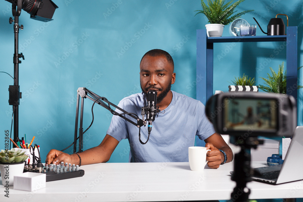 Poster african american vlogger using volume controller console and recording video with professional camer