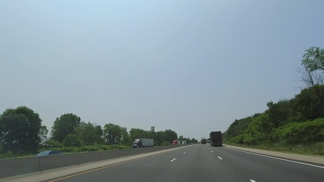 Point of view, car front view driving view,  POV on highway during travel. Roads of Canada. Car driving on road with traffic. Countryside adventure travelling on the 401 Highway, Ontario, Canada 