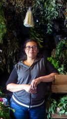 Horizontal portrait of a woman in front of her herb and vegetable business. Taken in Merida, Venezuela. Health and body care concept. Healthy food. Traditions. real people.