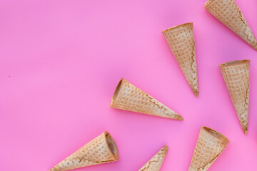 Empty ice cream cone on pink background.