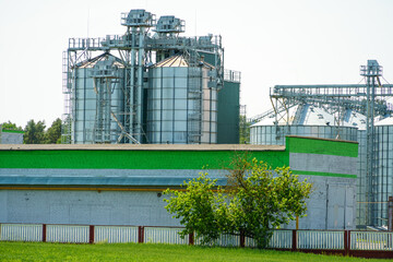 Fototapeta premium A large modern plant for the storage and processing of grain crops. view of the granary on a sunny day against the blue sky. End of harvest season.