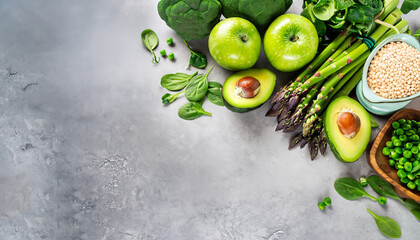 Healthy Green food Clean eating selection Protein source for vegetarians: avocado, asparagus, apple, broccoli, spinach, spirulina, green peas on gray concrete background