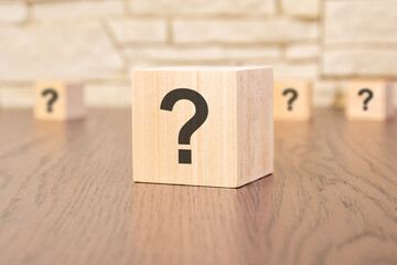 wooden blocks with question sign on wooden table, close up. space for text