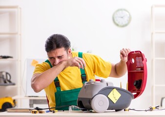 Man repairman repairing vacuum cleaner