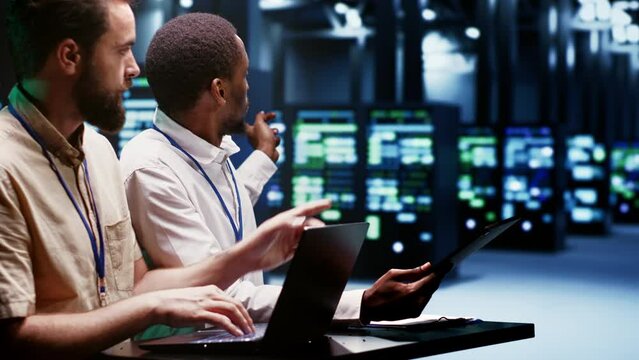 Teamworking experts doing maintenance on servers helping businesses manage databases, host websites and store files. Engineers monitoring supercomputers used for high performance computing