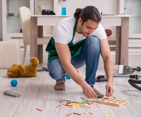 Young male contractor cleaning the flat after kids' party