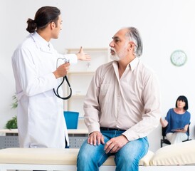 Obraz premium Old couple visiting young male doctor